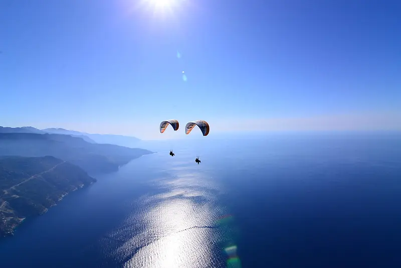 蓝色海面上的降落伞海报背景